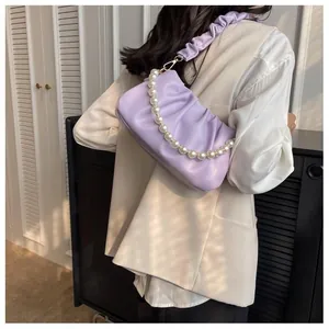 Detail of light purple pleated cloud bag with pearl strap and ruffled shoulder handle