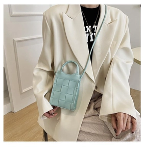 Fashionable light blue woven mini crossbody bag shown worn with a white blazer