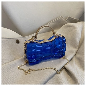 Détail de la pochette de soirée bleu marine en forme de nœud avec chaîne dorée