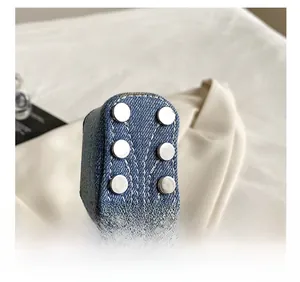 Detail of denim guitar bag with double stitching and silver metal rivets decor