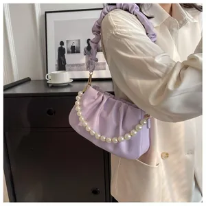 Detail of light purple pleated shoulder bag with decorative white pearl chain strap
