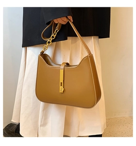 Chic brown leather shoulder bag with gold chain strap shown on professional model