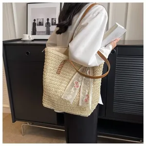 Close-up of woven straw tote bag featuring a floral lace scarf and brown leather strap