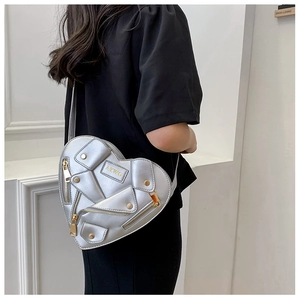 Detailed view of heart-shaped silver biker bag with metallic finish and zipper decor