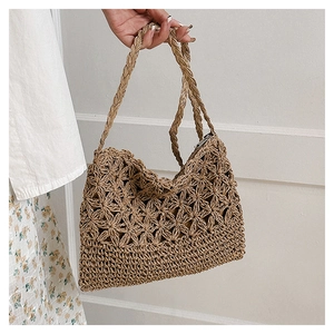 Détail d'un sac cabas en paille tissé à la main avec motifs d'étoiles et fermeture