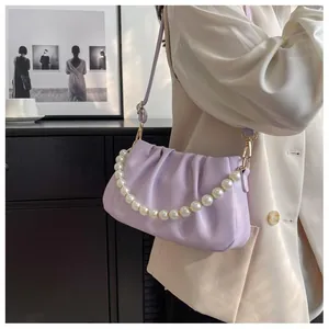Detailed close-up of a soft lavender cloud bag with elegant pearl chain and pleated texture