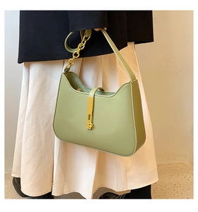 Detail of light green crescent shoulder bag with golden hardware lock and chain