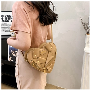 Detailed side view of the heart-shaped biker jacket crossbody bag in matte tan PU leather