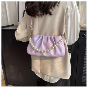 Detail of lavender ruched cloud bag featuring pearl handle and soft pleated leather