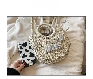Détail du sac en paille tressé à la main avec lettrage MISS en perles et cœur