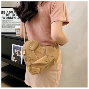 Detail of coffee brown heart-shaped biker bag with zippers and metallic rivets