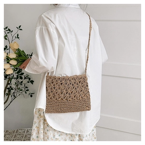 Détail du sac bandoulière en paille tissé main avec motif floral évidé et maille plate