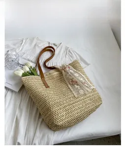 Detail of straw woven tote with floral lace scarf and brown leather straps