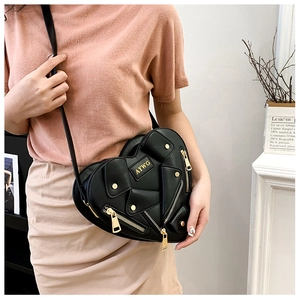 Detail of a black heart-shaped biker jacket bag featuring gold zippers and lapel elements