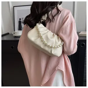 Detail of creamy white pleated cloud bag with pearl bead chain and soft leather texture