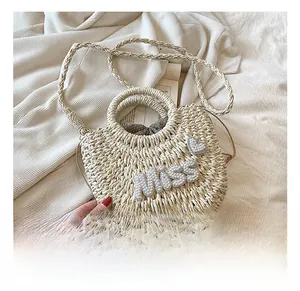 Détail du sac de plage en paille avec lettrage MISS en perles et motif de cœur