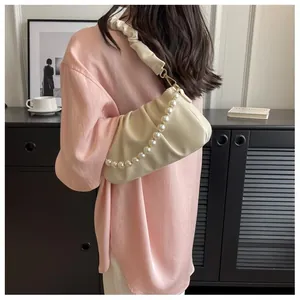 Detail of soft gathered cream cloud bag featuring premium pearl chain and pleated strap