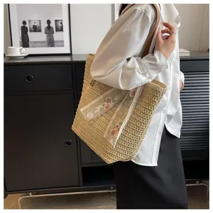 Detail of hand-woven straw tote bag with elegant white lace flower ribbons for summer