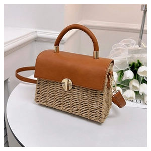 Detailed shot of textured beige woven crossbody bag with brown leather flap and gold lock