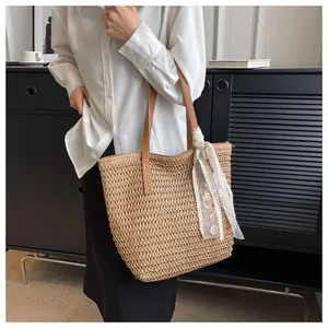 Woven tote bag detail featuring brown leather straps and a delicate lace floral scarf