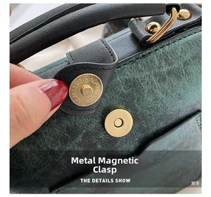 Détail de la boucle magnétique dorée sur un sac à main vert à texture crocodile