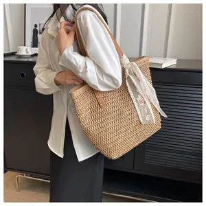Detail of straw tote bag showing natural woven texture and floral lace ribbon detail