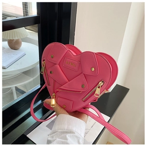 Close-up of heart-shaped crossbody bag with jacket design elements and gold zippers