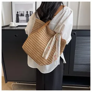 Detail of hand-woven straw tote with lace floral scarf and brown leather shoulder strap