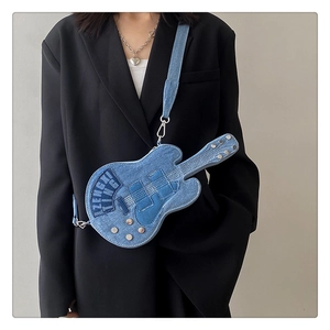 Detail of guitar-shaped denim crossbody bag with metal studs and contrast stitching