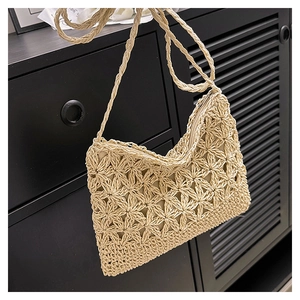 Détail de la maille florale ajourée sur un sac bandoulière en paille tressée