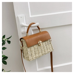 Macro detail of woven straw texture and brown leather flap with gold metal lock