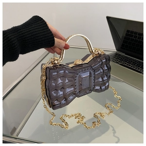 Détail du sac à nœud gris translucide avec poignée en or strass et bandoulière