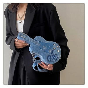 Detail of guitar shaped denim crossbody bag with metallic rivets and stitched brand patch