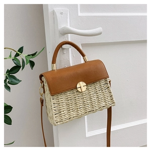 Close-up of beige woven texture and dark brown leather flap with golden metal lock