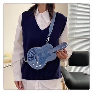 Detail shot of guitar-shaped denim crossbody bag worn by a model in light blue finish