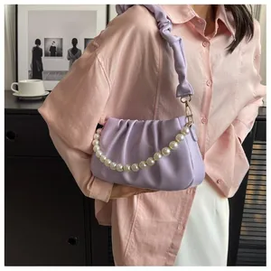 Close-up of light purple cloud bag with pleated texture and decorative pearl chain strap