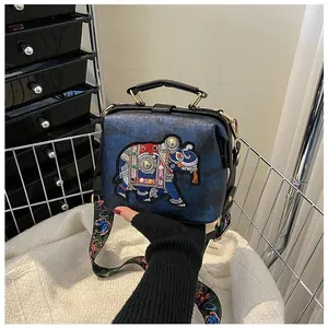Détail de broderie d'éléphant thaïlandais sur un sac docteur vintage en cuir bleu brodé