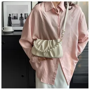 Close-up of beige pleated cloud bag featuring pearl chain strap and soft leather folds