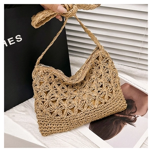 Gros plan détaillé du sac à bandoulière tissé à la main avec motifs floraux et fermeture