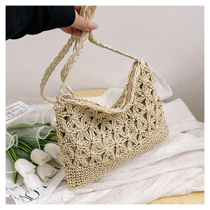 Gros plan détaillé d'un sac en paille beige au crochet avec motifs floraux ajourés