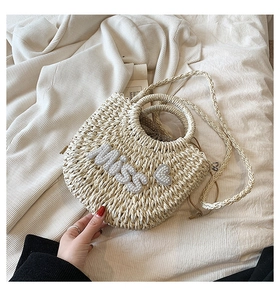 Détail du sac coquillage en paille tissée avec lettrage Miss en perles et motif de cœur