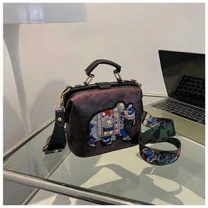 Détail du sac violet exotique avec broderie éléphant et bandoulière papillon