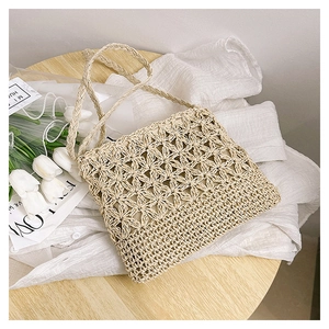Détail de sac en paille fait main avec motifs étoilés ajourés et texture tissée élégante