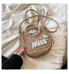 Détail du sac en paille avec lettres en perles et doublure à pois à cordon