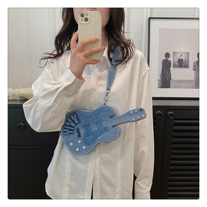 Detailed close-up of blue denim guitar-shaped crossbody bag with intricate embroidery