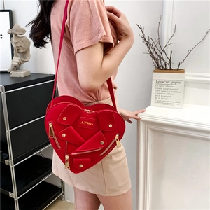 Red heart-shaped crossbody bag featuring motorcycle jacket design and metallic zipper details