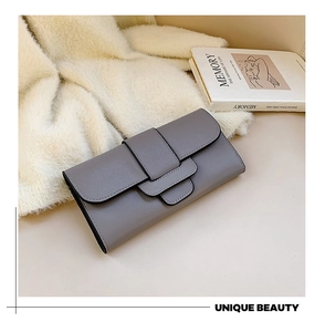 Gray leather long wallet with fold-over design and fine black edge detail on plush surface