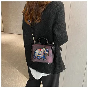 Vue détaillée du sac docteur violet avec broderie d'éléphant thaïlandais et bandoulière