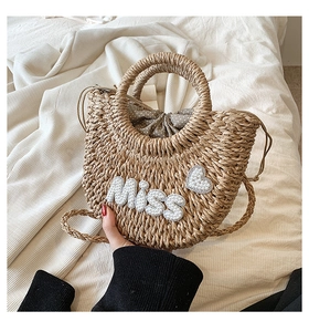 Détail du sac coquille en paille tressée avec lettres en perles et doublure à pois chic