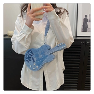Detailed close-up of blue denim guitar-shaped crossbody bag featuring metallic silver studs